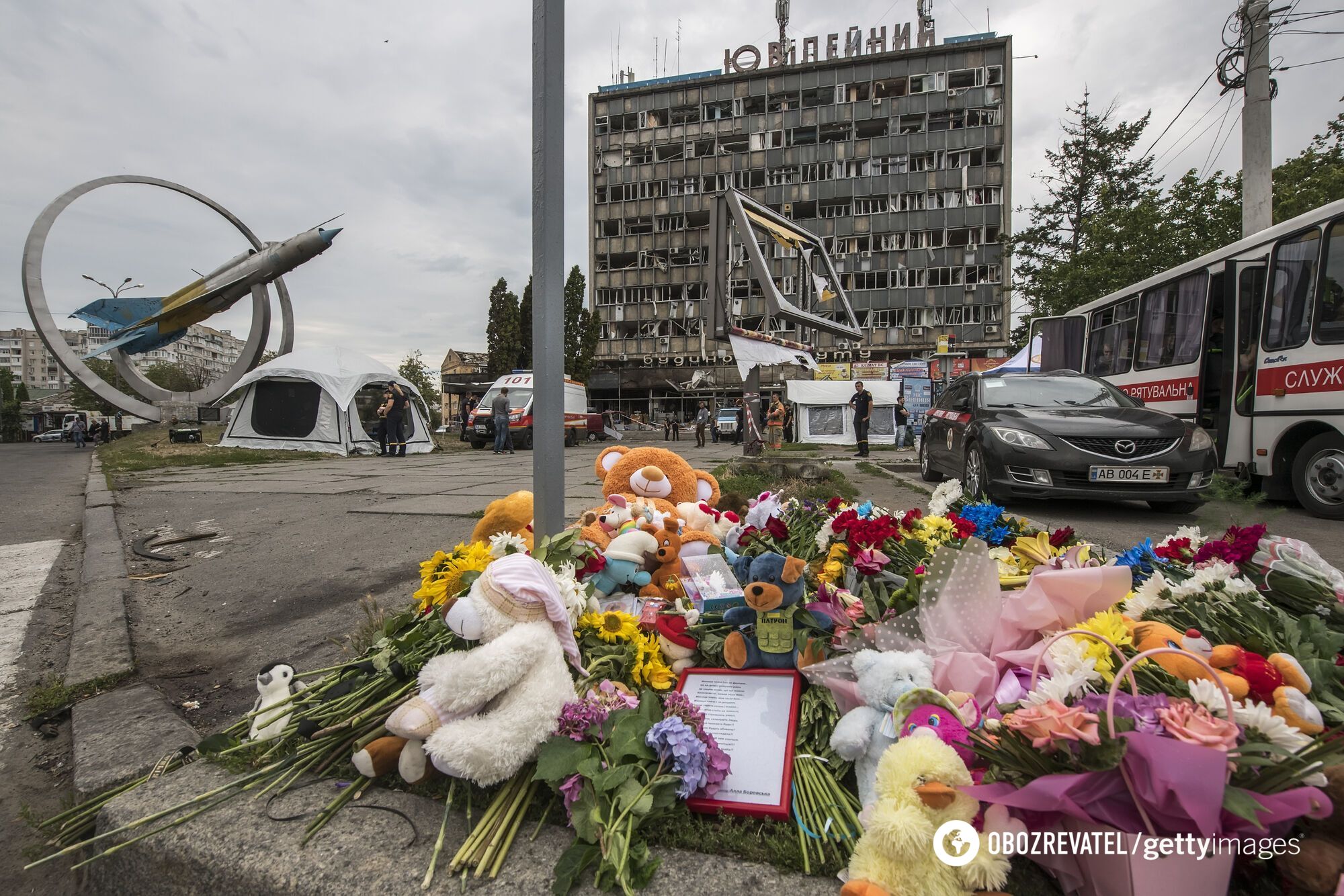 Жители Винницы несут игрушки к месту, где накануне российские ракеты убили украинцев