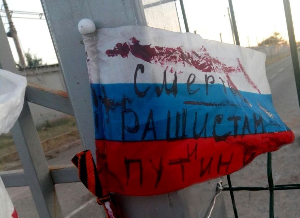 На прапорі РФ на гуманітарному штабі окупантів в ТЦ "Метро" невідомі написали "Смерть рашистам і Путіну"
