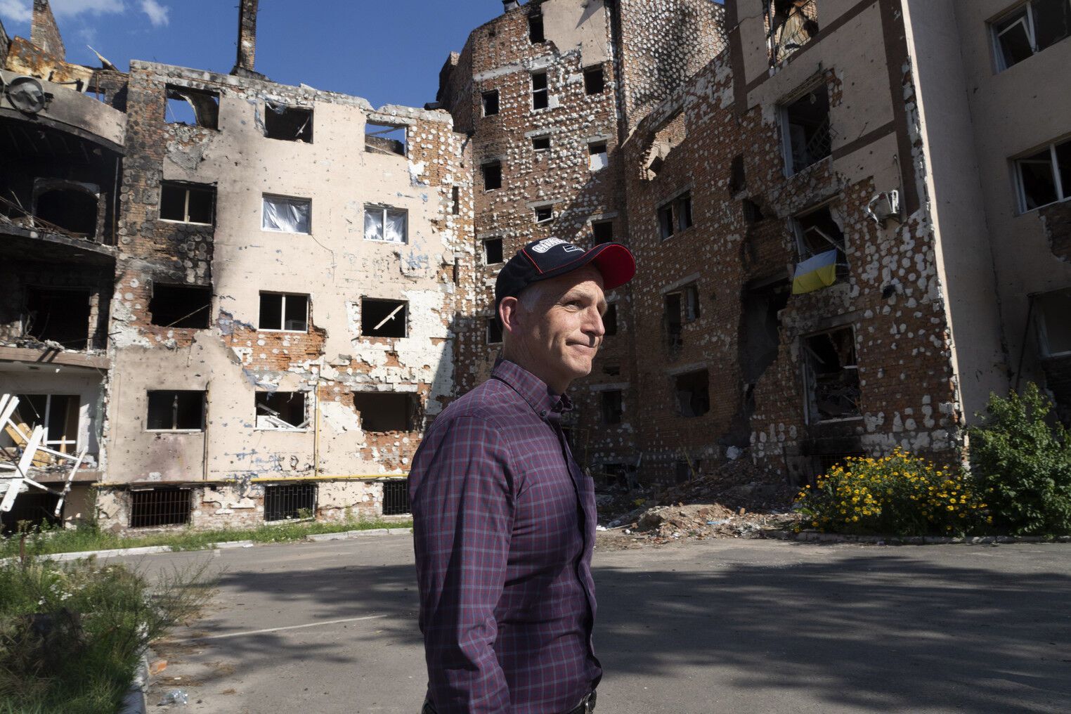 Адам Сміт дивиться на будинки, зруйновані російськими обстрілами в Ірпені