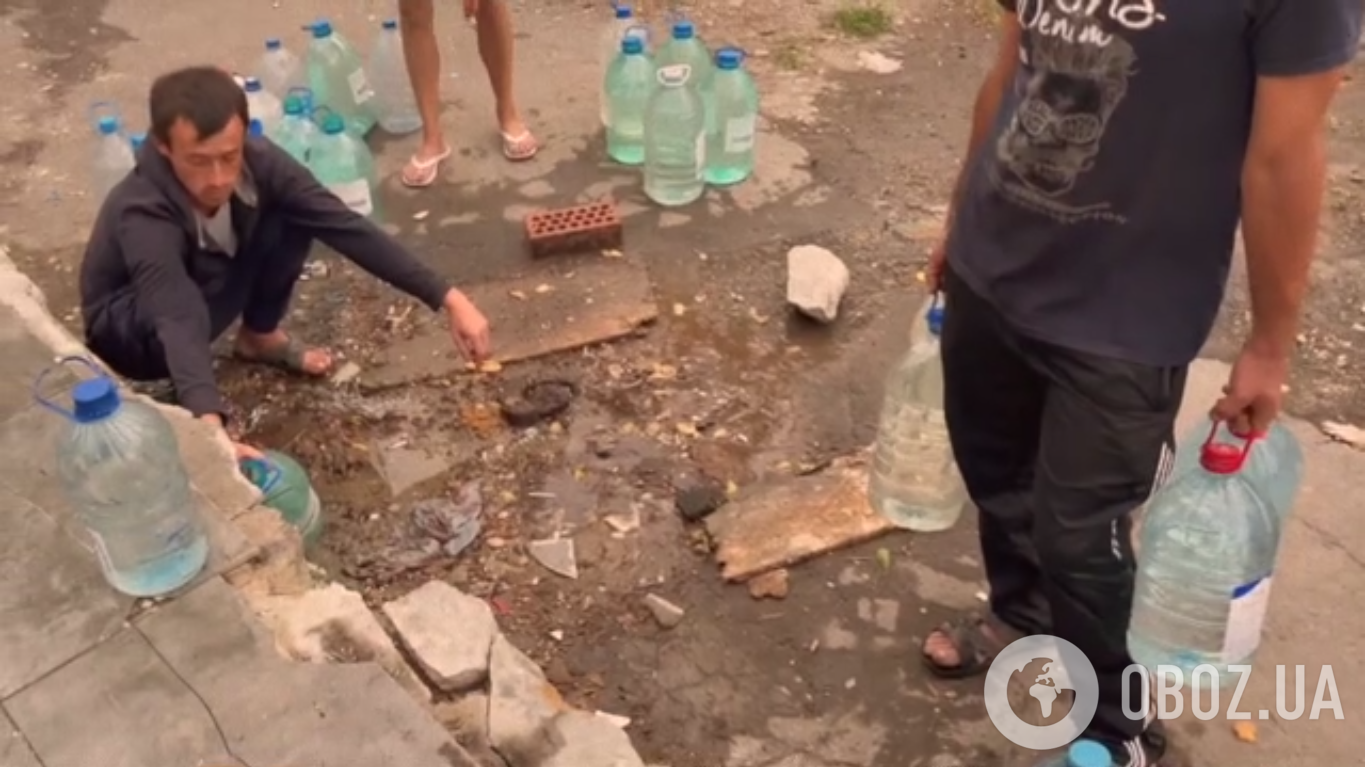 Люди набирают воду в бутылки и баклажки