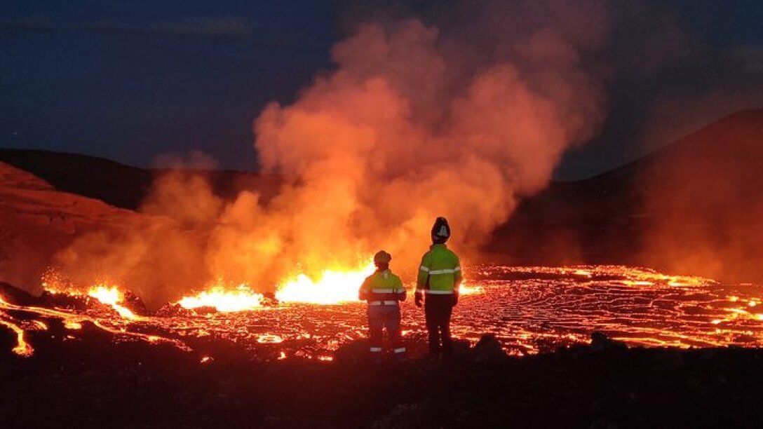 Люди смотрят на извержение вулкана Фаградальсфьядль в Исландии