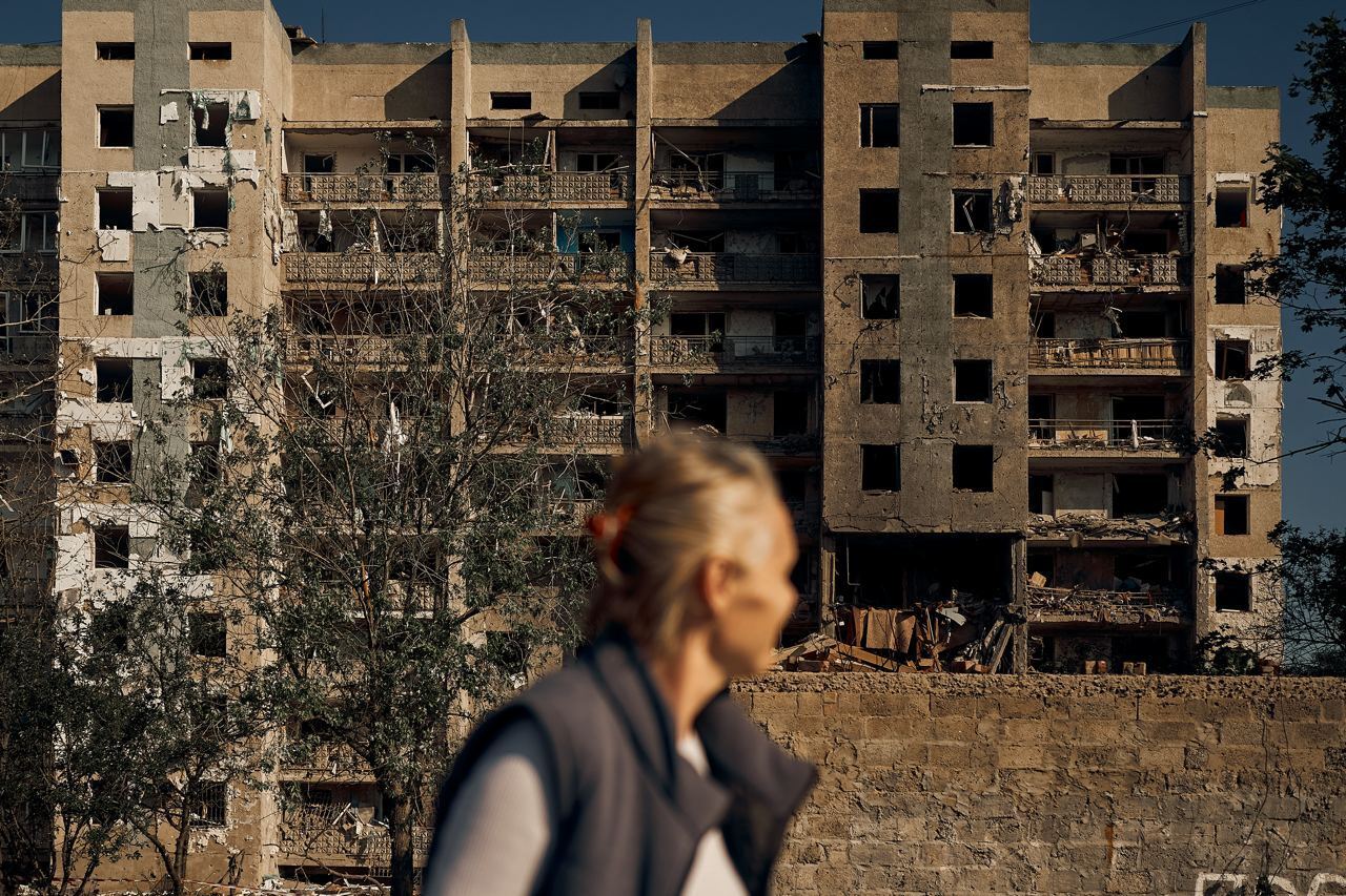 Украинка смотрит на здание, которое разрушила Россия