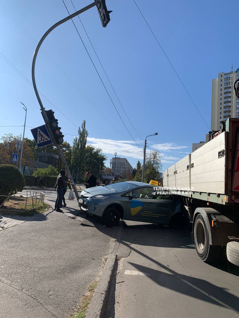 У Києві сталась аварія за участі таксі: легковик затисло між вантажівкою та світлофором. Фото
