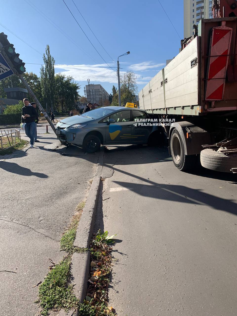 В Киеве произошла авария с участием такси: легковушку зажало между грузовиком и светофором. Фото