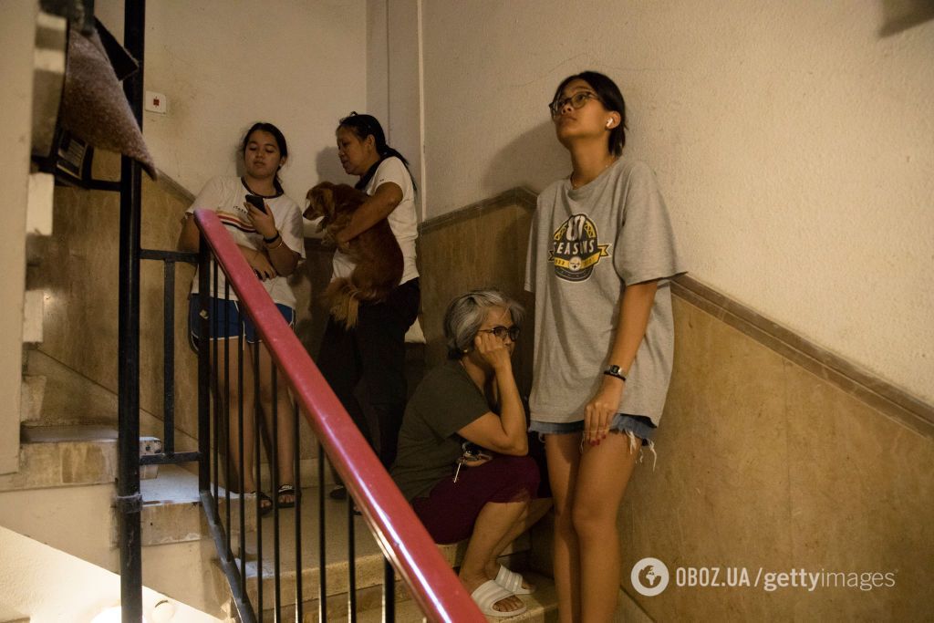 Люди прячутся на лестнице здания после звука сирены. Тель-Авив