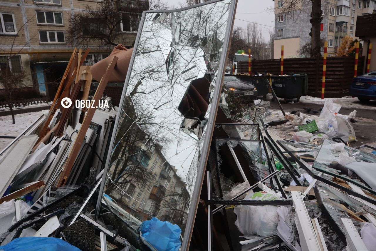 Глибока вирва біля під’їзду будинку та обгорілі авто: нові фото та відео наслідків падіння уламків ракети в Києві