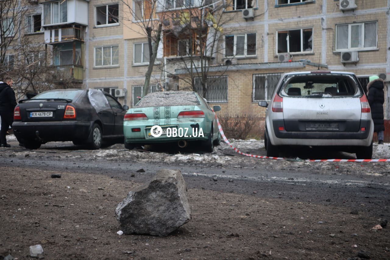 Глибока вирва біля під’їзду будинку та обгорілі авто: нові фото та відео наслідків падіння уламків ракети в Києві