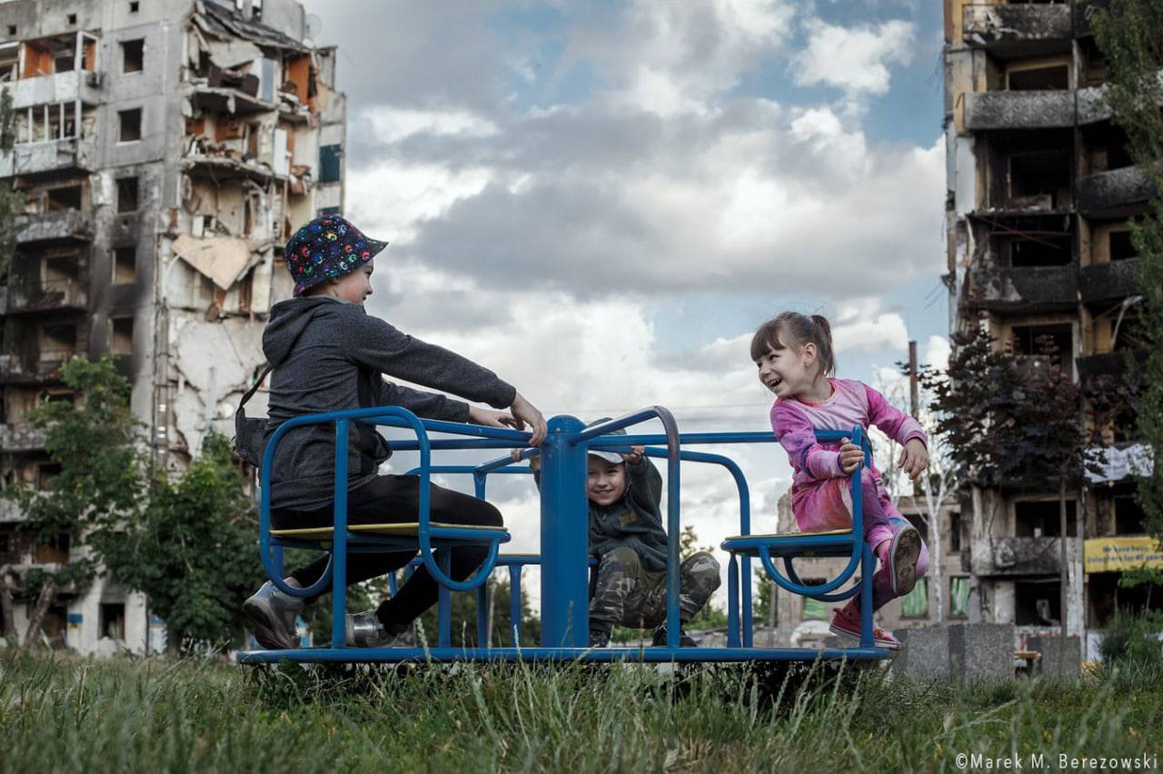 Дети играют во дворе, который пострадал от российских обстрелов