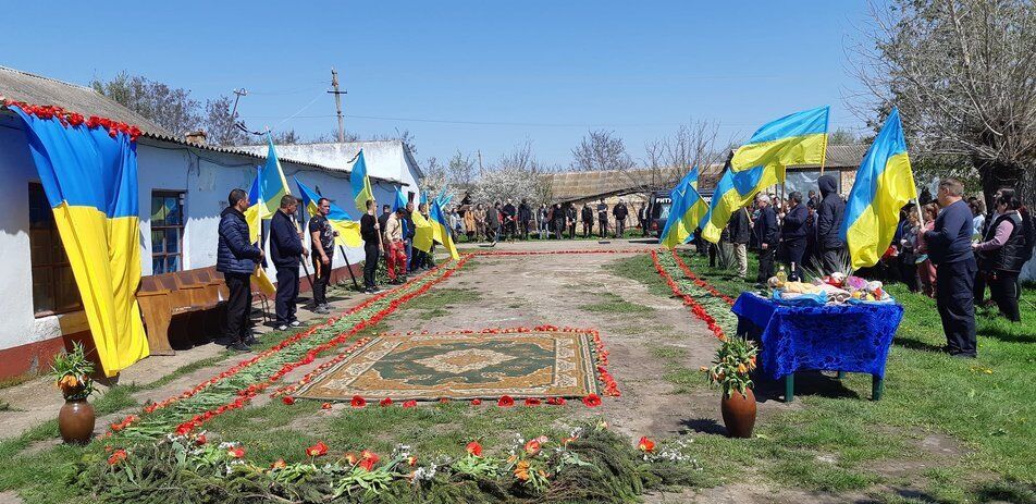 Место прощания с воином украсили цветами и флагами Украины