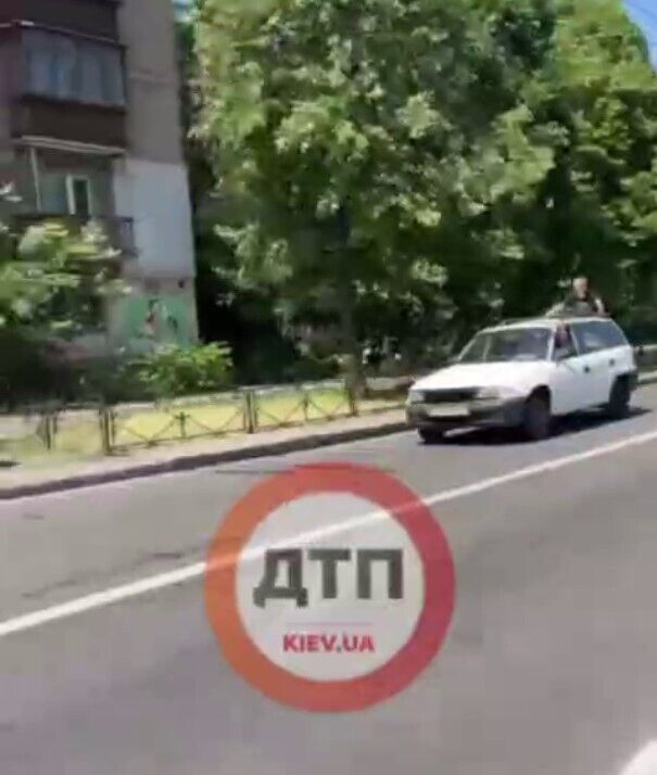 Катался, стоя на бампере авто: в Киеве мужчина устроил опасные развлечения. Видео