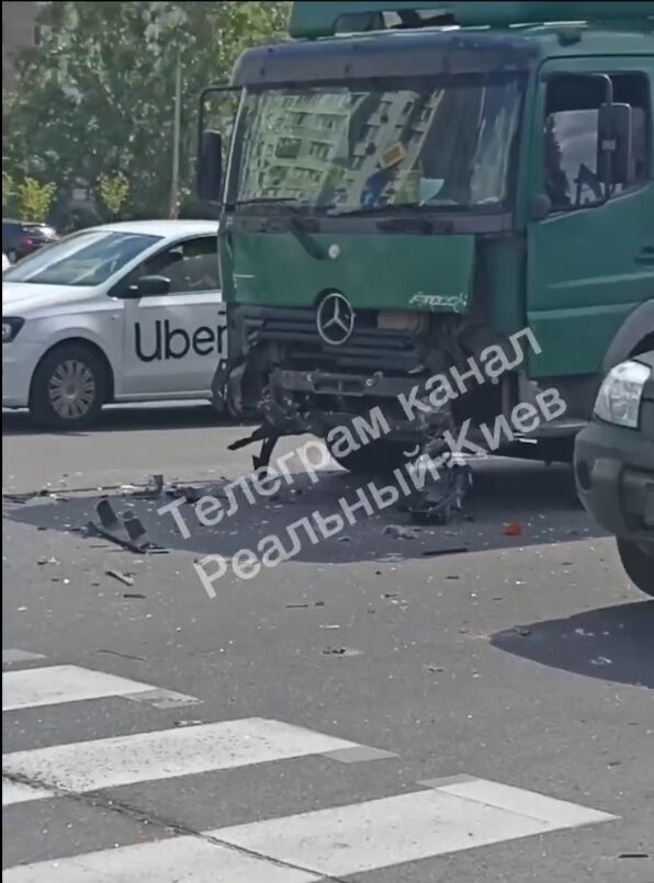 У Києві легковик зіткнувся із вантажівкою, протаранив огорожу парковки та перекинувся. Фото і відео