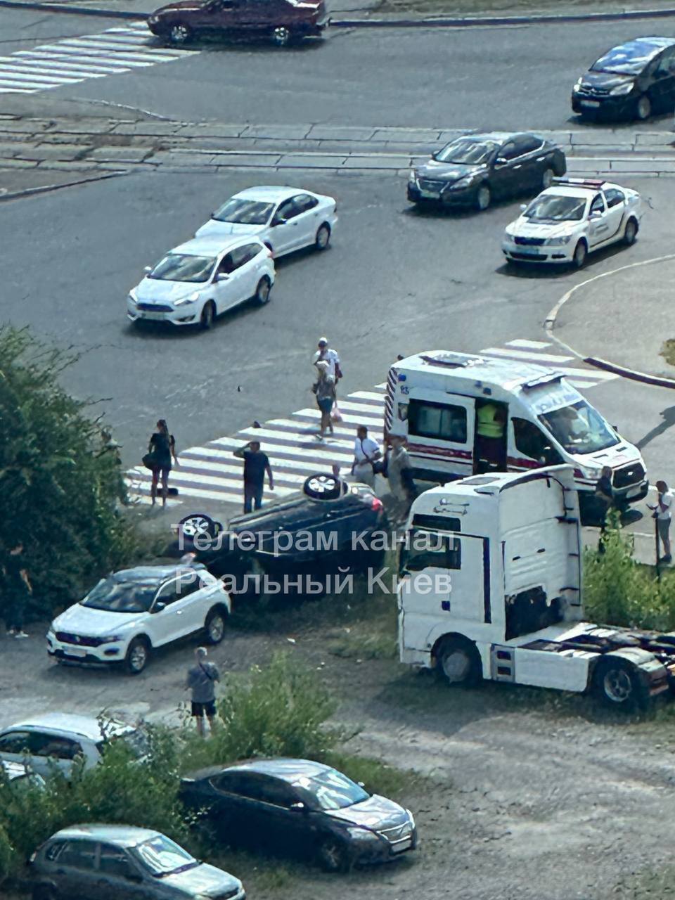 У Києві легковик зіткнувся із вантажівкою, протаранив огорожу парковки та перекинувся. Фото і відео