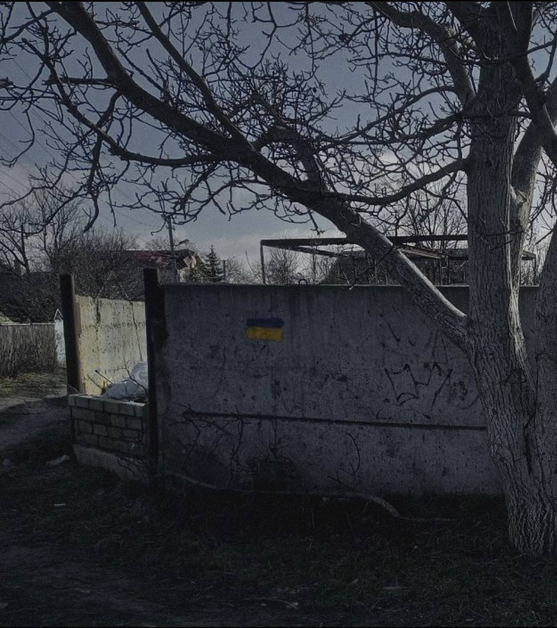 В оккупированных Олешках у дома, где поселились захватчики, появились граффити с сине-желтым флагом. Фото