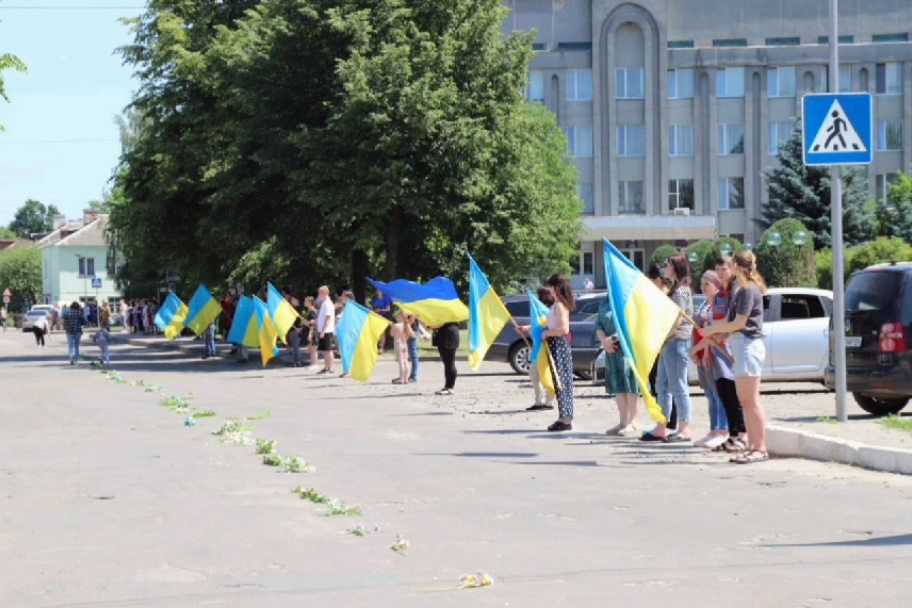 Военнослужащего на щите встречали с флагами и цветами