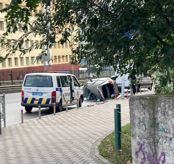 У Києві біля Індустріального мосту легковик в’їхав в електроопору та перекинувся. Фото і відео