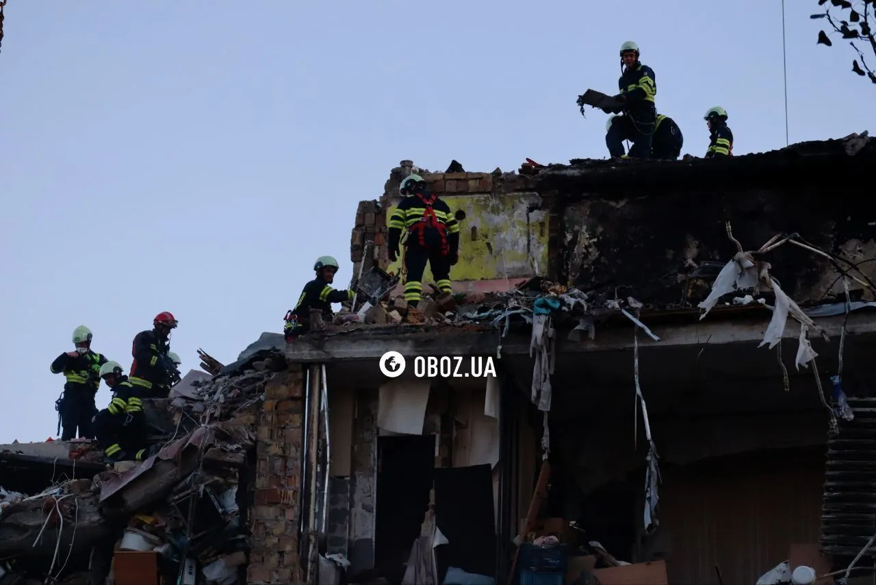 "Не втрачають надії": у Києві під прожекторами розбирають завали на місці удару РФ, люди приносять іграшки у пам'ять про загиблих дітей. Фото та відео