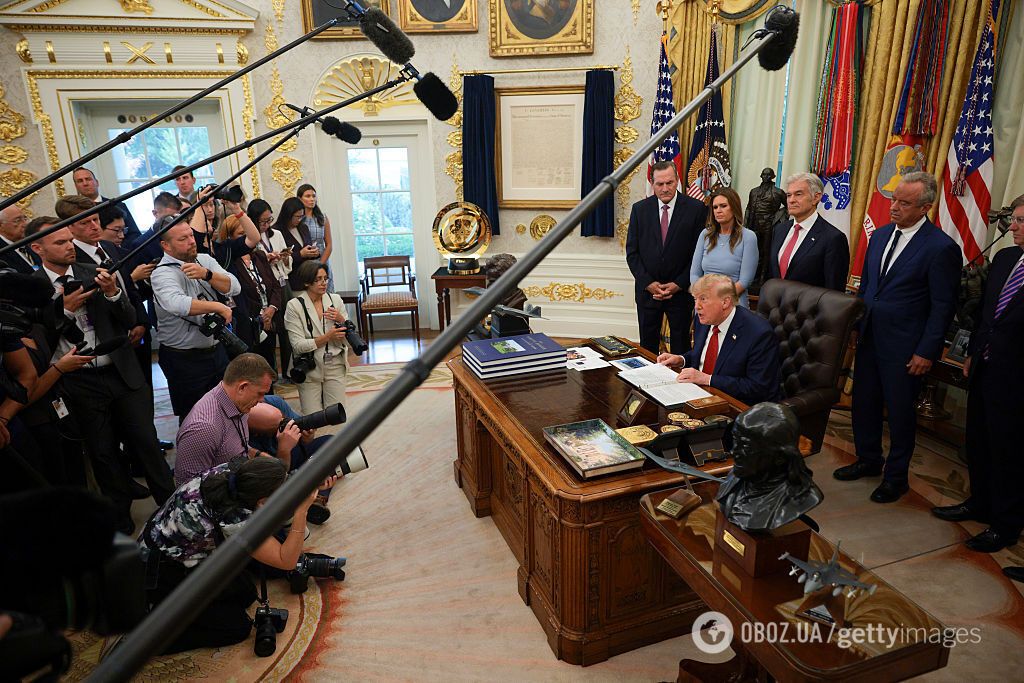 Дональд Трамп общается с журналистами в Овальном кабинете.