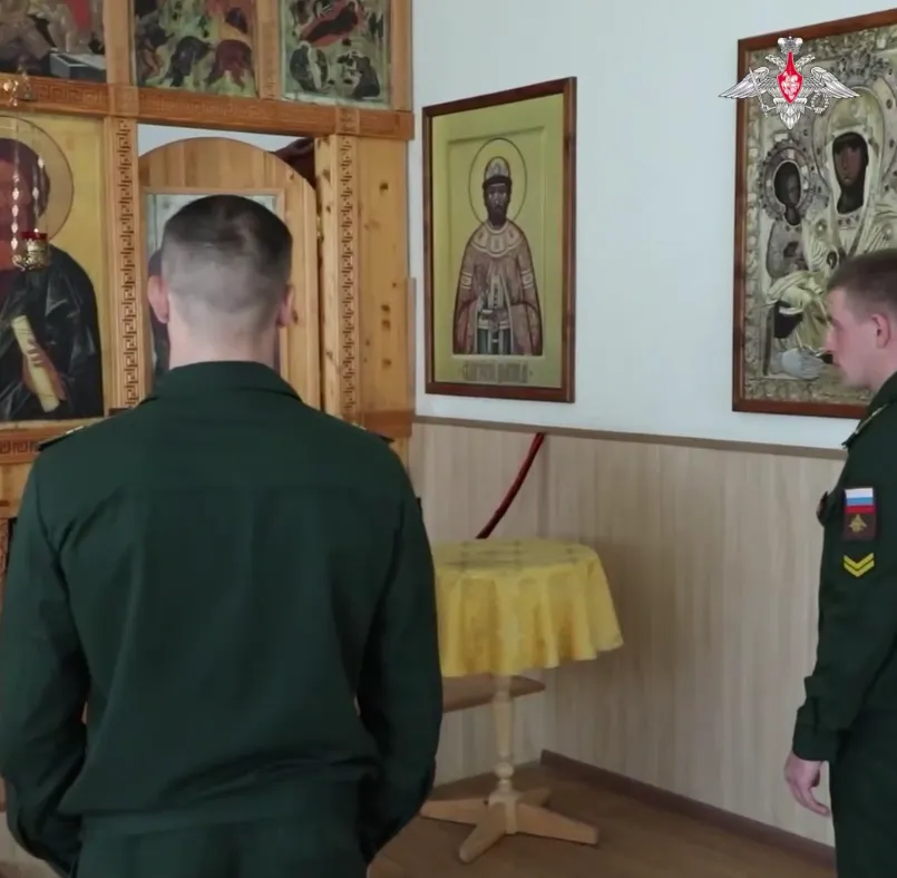 Курсанти військового вишу, хрестяться перед іконостасом у храмі,.