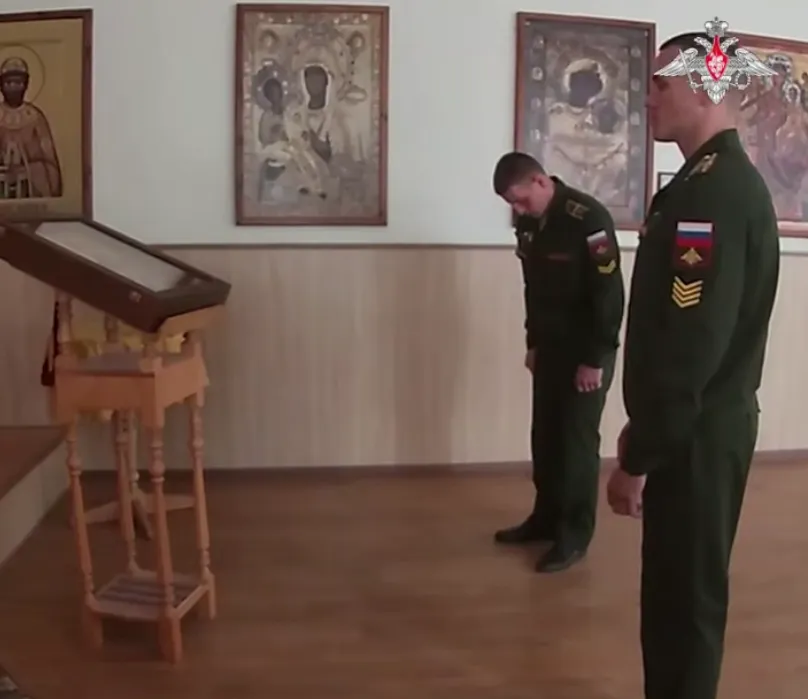Курсанти військового вишу, хрестяться перед іконостасом у храмі.