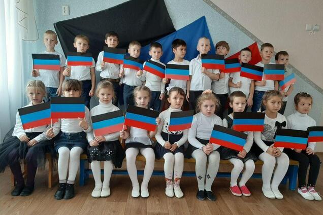 Детей в садике Харцызска фотографируют с флагами террористов