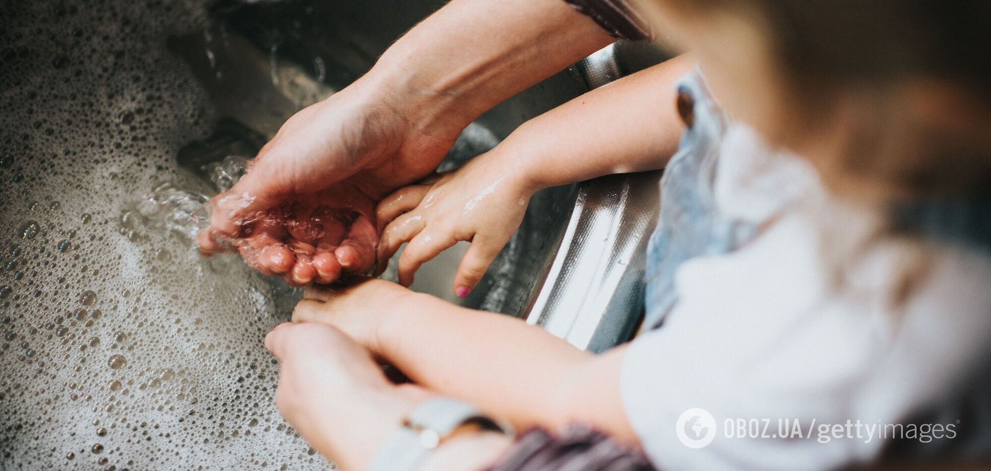 Дорослий і дитина миють руки в тазі