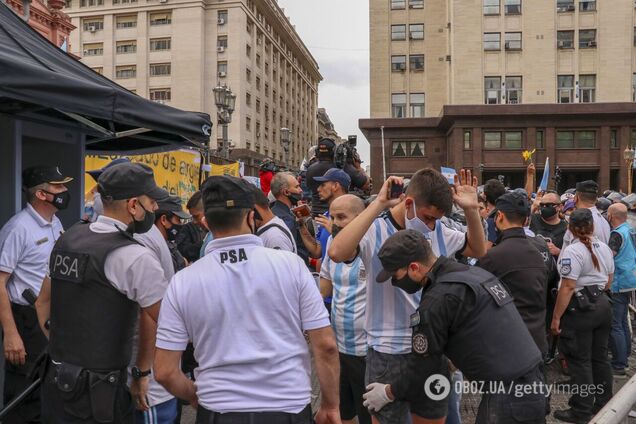 Одного из поклонников Марадоны обыскивают перед входом в президентский дворец