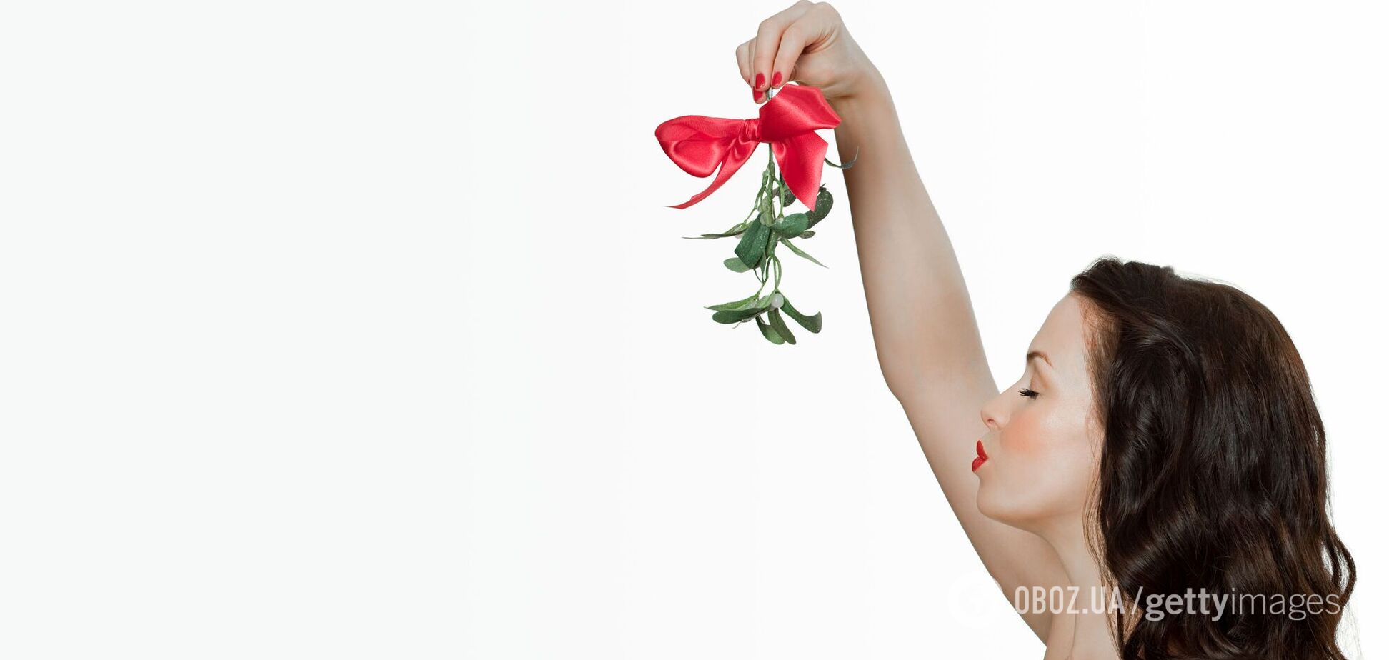 Дівчина стає під гроном омели і чекає, поки коханий її поцілує