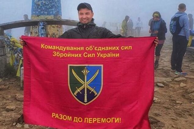 Волонтер Руслан Костюченко з прапором захисників у Карпатах (джерело: Facebook Анатолія Штефана)