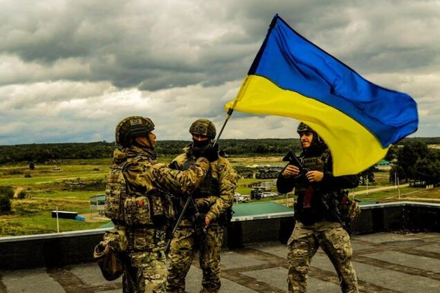 Українські військові встановлюють державний прапор у деокупованому населеному пункті