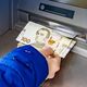 Снятие купюр по 100 грн в банкомате. Иллюстрация