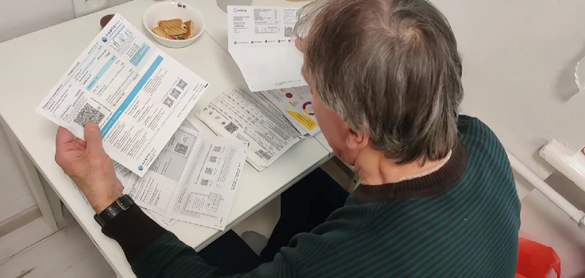 Ілюстративне фото, чоловік розглядає комунальні платежі