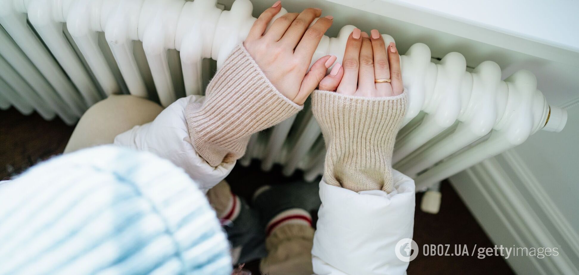 Жінка гріє руки на батареї. Ілюстрація