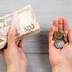 Иллюстративное фото. Человек держит в руках украинские деньги, купюры 500 гривен