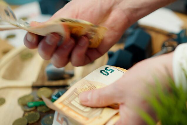 Ілюстрація - чоловік рахує гроші в євро