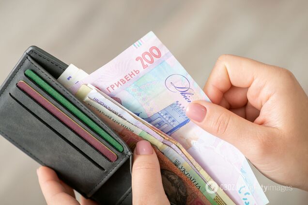 Купюры украинской гривны в кошельке как символ пенсии