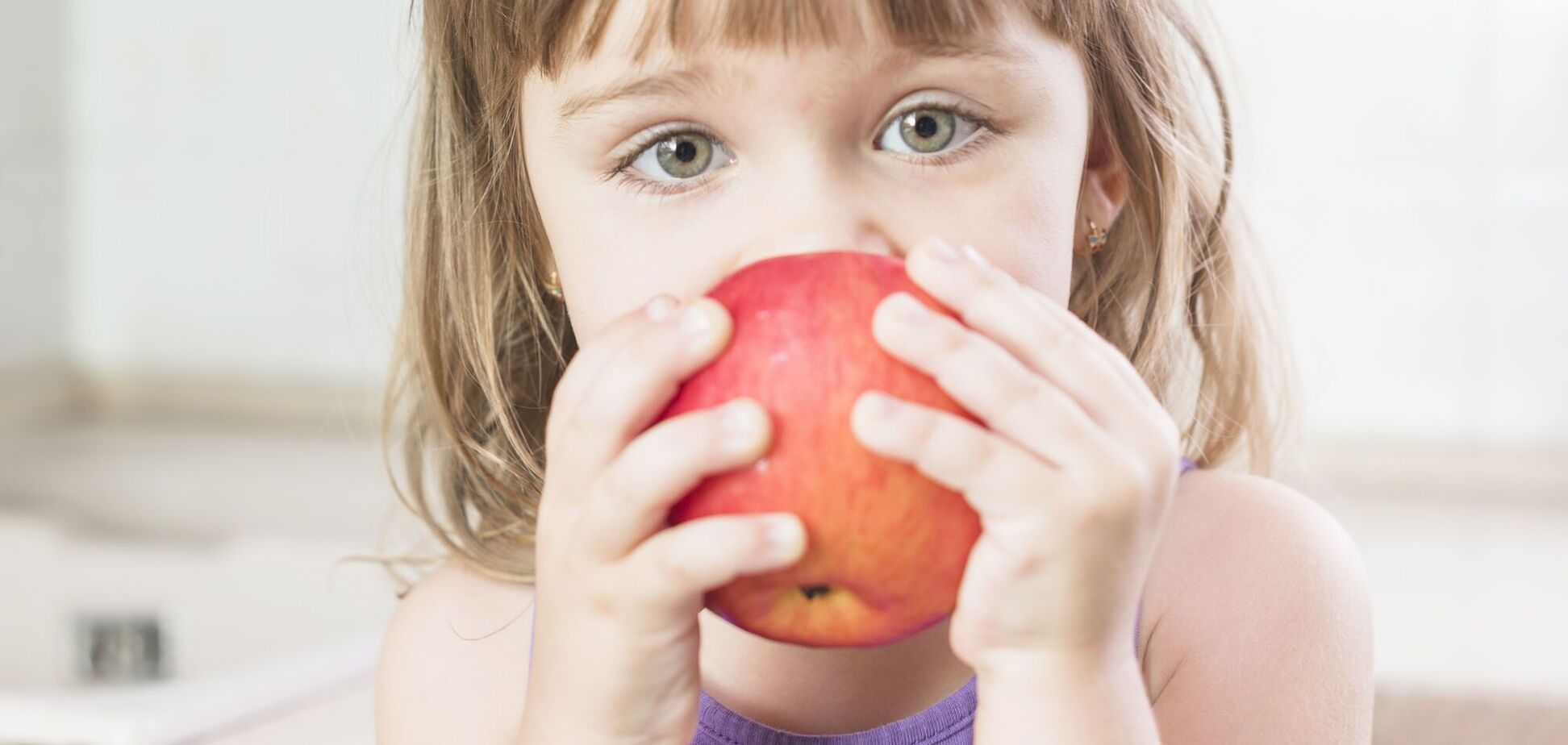 Иллюстрация - девочка держит яблоко перед лицом