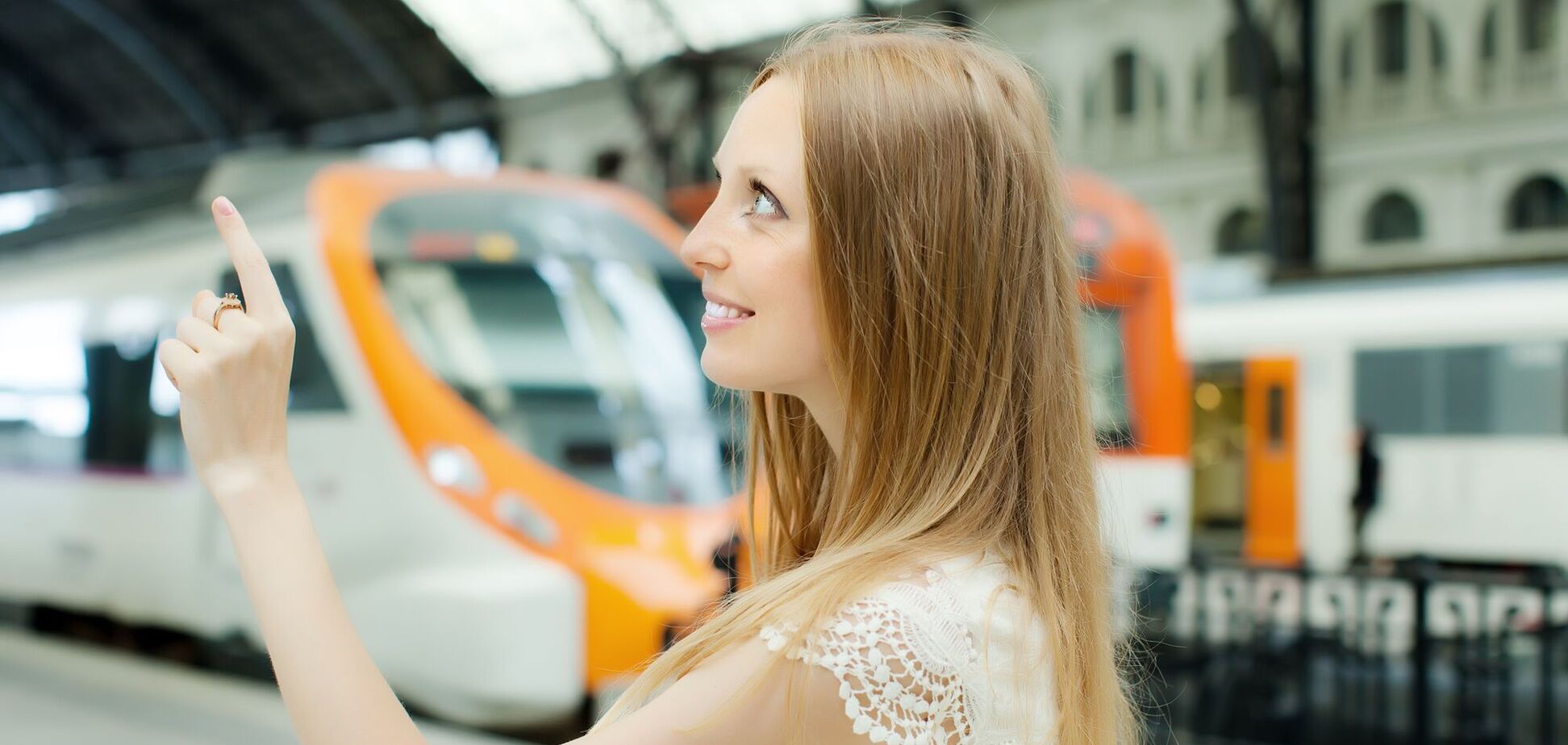Ілюстрація - жінка розглядає розклад поїздів на пероні