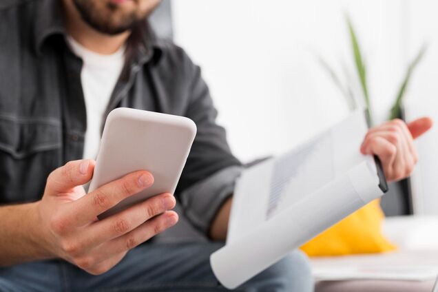 Ілюстрація - чоловік тримає смартфон та документ