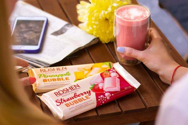 Иллюстрация - женщина держит плитку шоколада Roshen, сидя с подругой