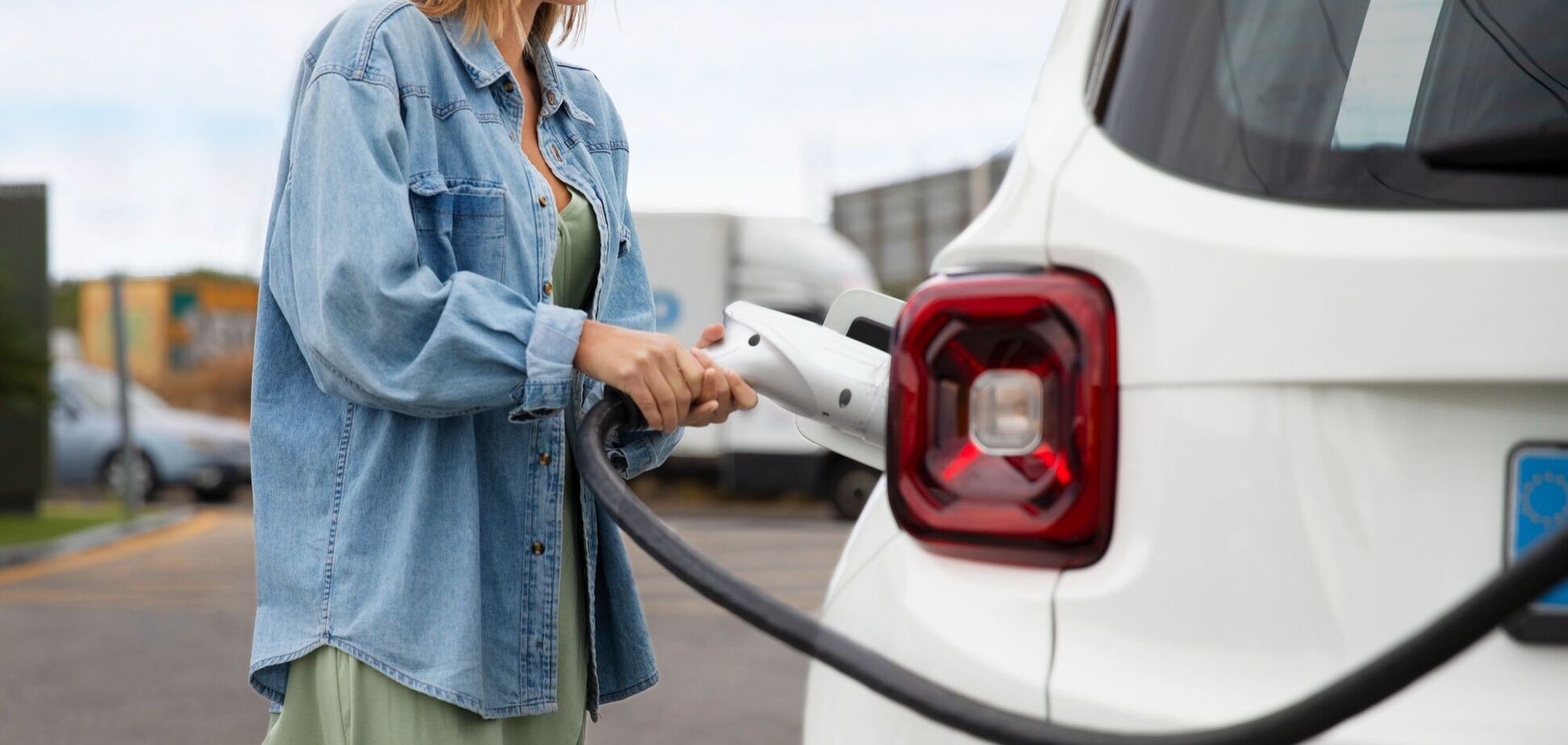 Иллюстрация - женщина заряжает электромобиль