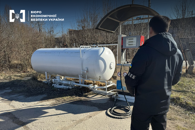 Ілюстрація - правоохоронець поруч з баком для зберігання пального