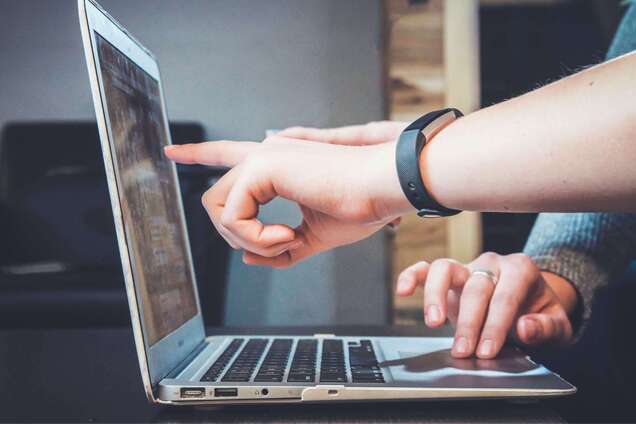 Рука вказує на екран ноутбука. Ілюстрація