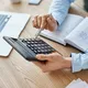 Иллюстрация - бухгалтер проводит расчеты на калькуляторе