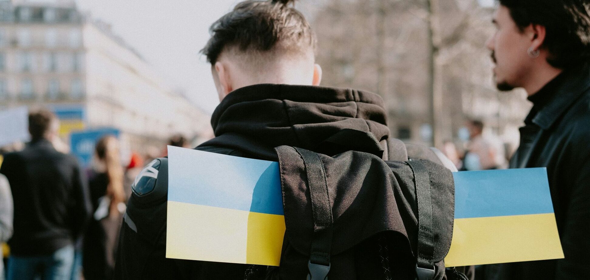 Иллюстрация - мужчина с флажками Украины в рюкзаке