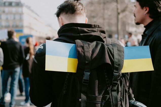 Ілюстрація - чоловік з прапорцями України в рюкзаку