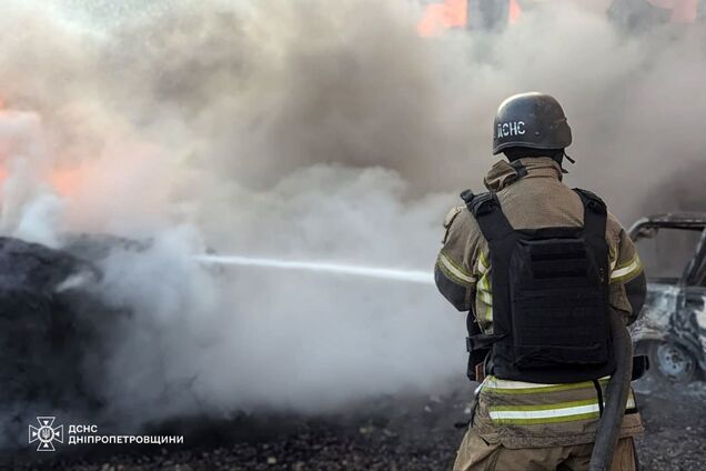 Иллюстрация - сотрудник ГСЧС тушит пожар после обстрела РФ