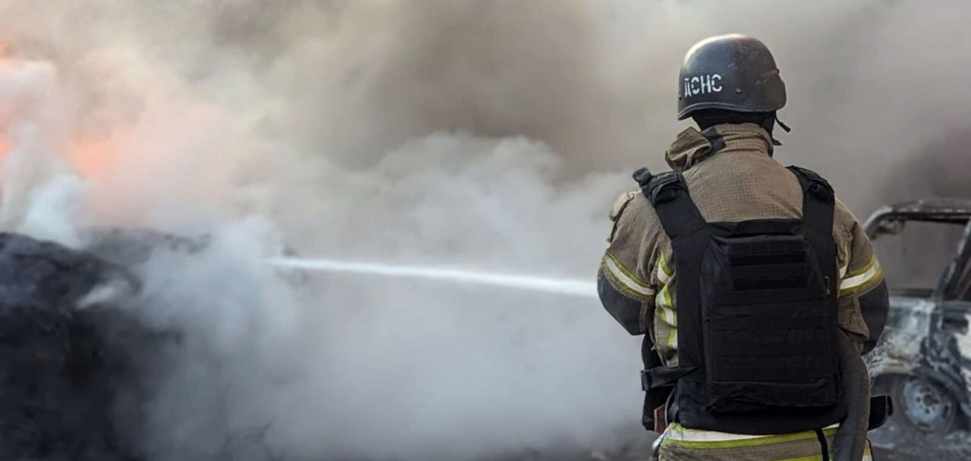 Иллюстрация - сотрудник ГСЧС тушит пожар после обстрела РФ