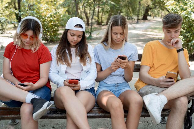 Ілюстрація - підлітки дивляться у смартфони