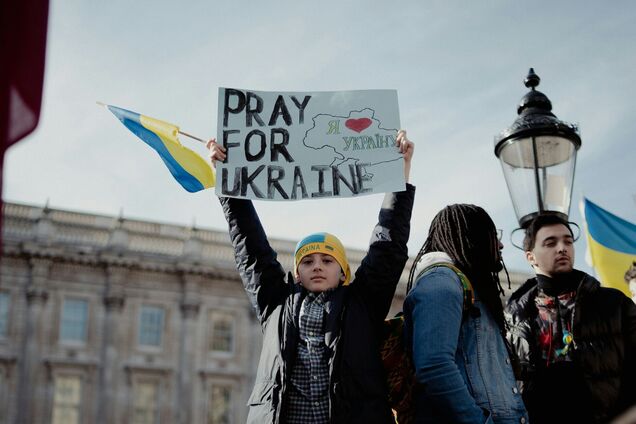 Ілюстрація - хлопчик з плакатом Моліться за Україну