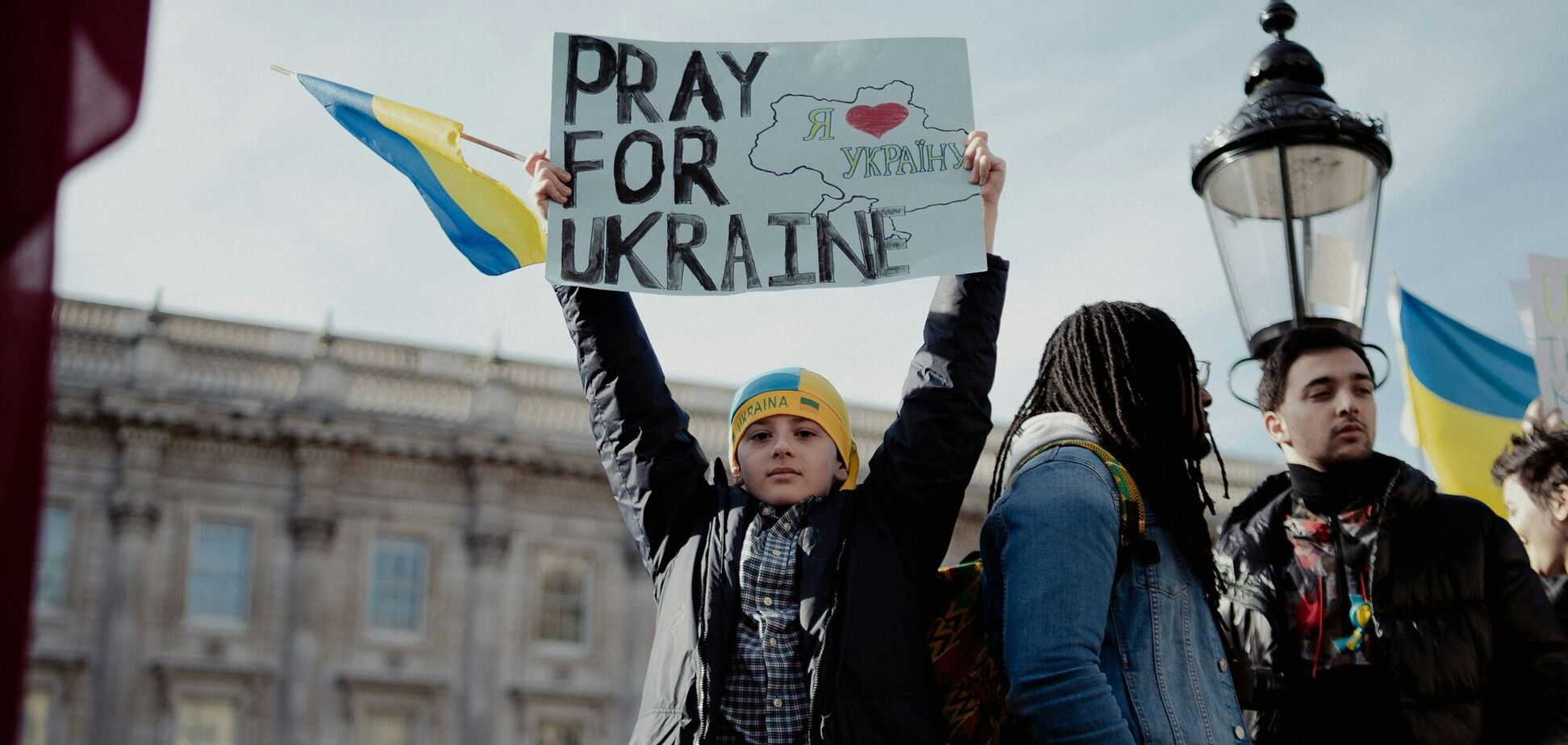 Ілюстрація - хлопчик з плакатом Моліться за Україну